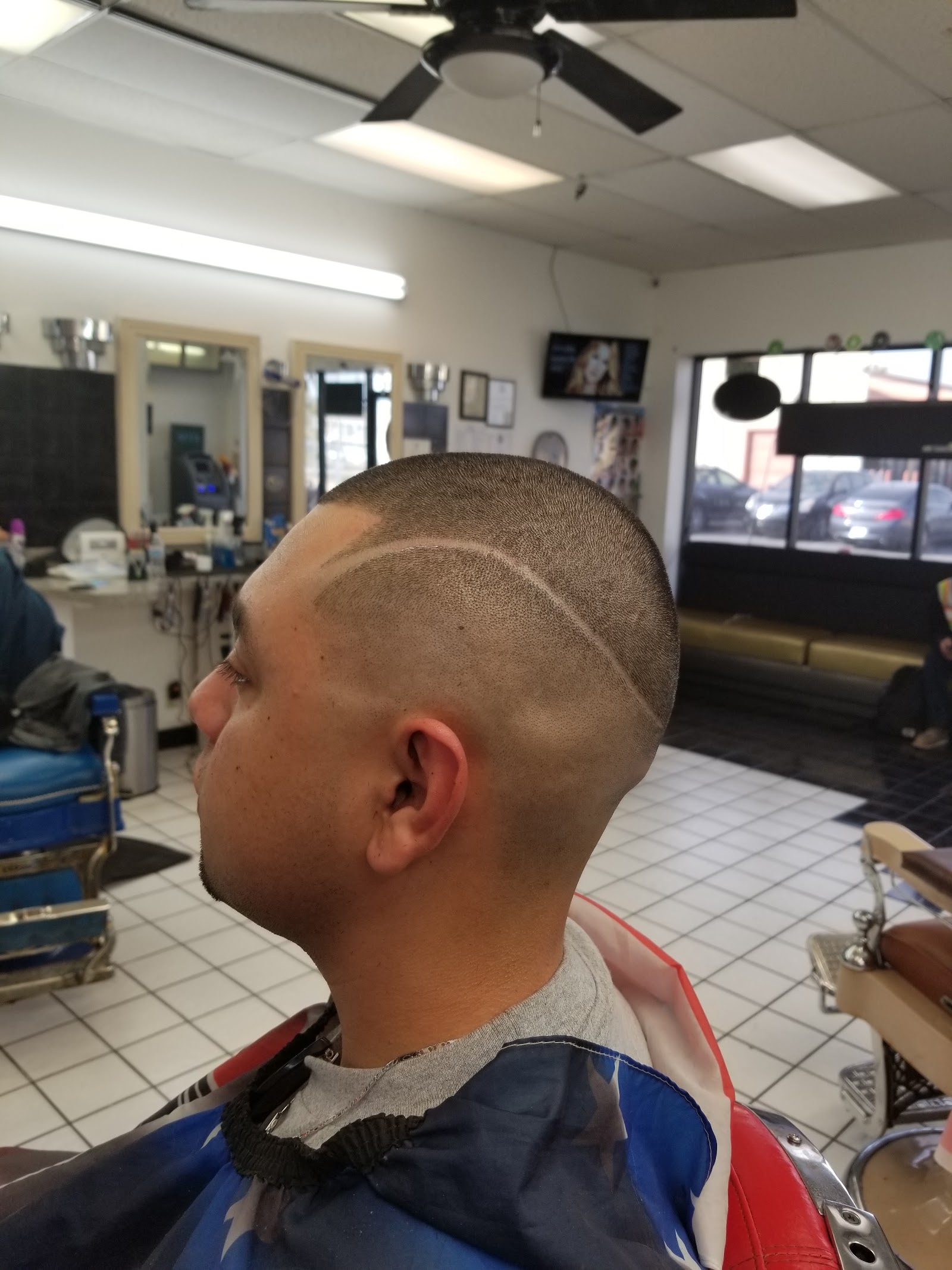 Side view of a man's fresh buzz cut with a hair design line and clean fade